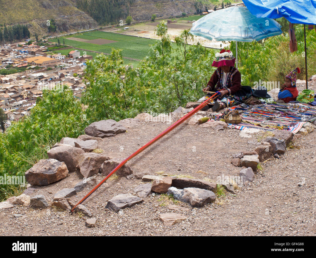 A local Andean woman weaving and selling her handicraft at the valley viewpoint Stock Photo