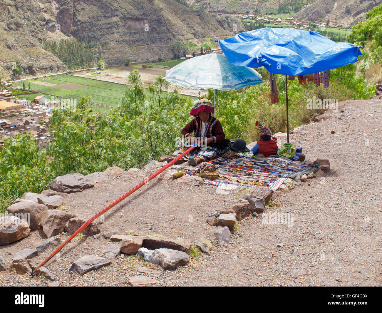 A local Andean woman weaving and selling her handicraft at the valley viewpoint Stock Photo