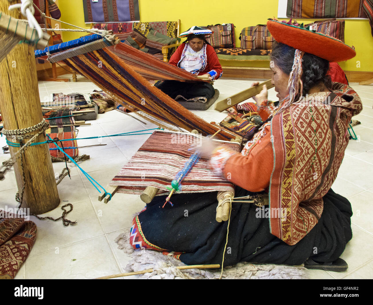Local Peruvian ladies demonstrating the traditional weaving method Stock Photo