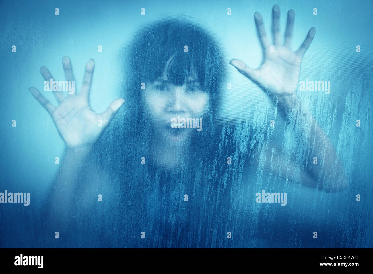 Woman screaming behind stained or dirty window glass,Scary background for book cover Stock Photo