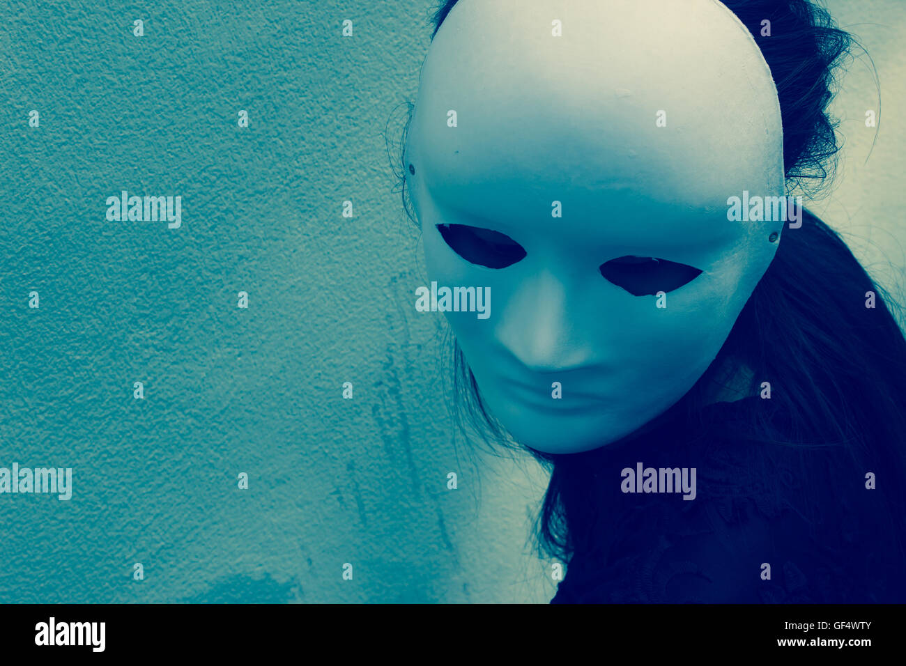 Mysterious woman in black dress wearing white mask,Scary background for