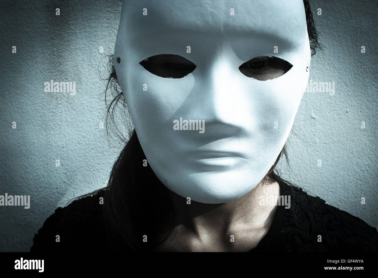 Mysterious woman in black dress wearing white mask,Scary background for