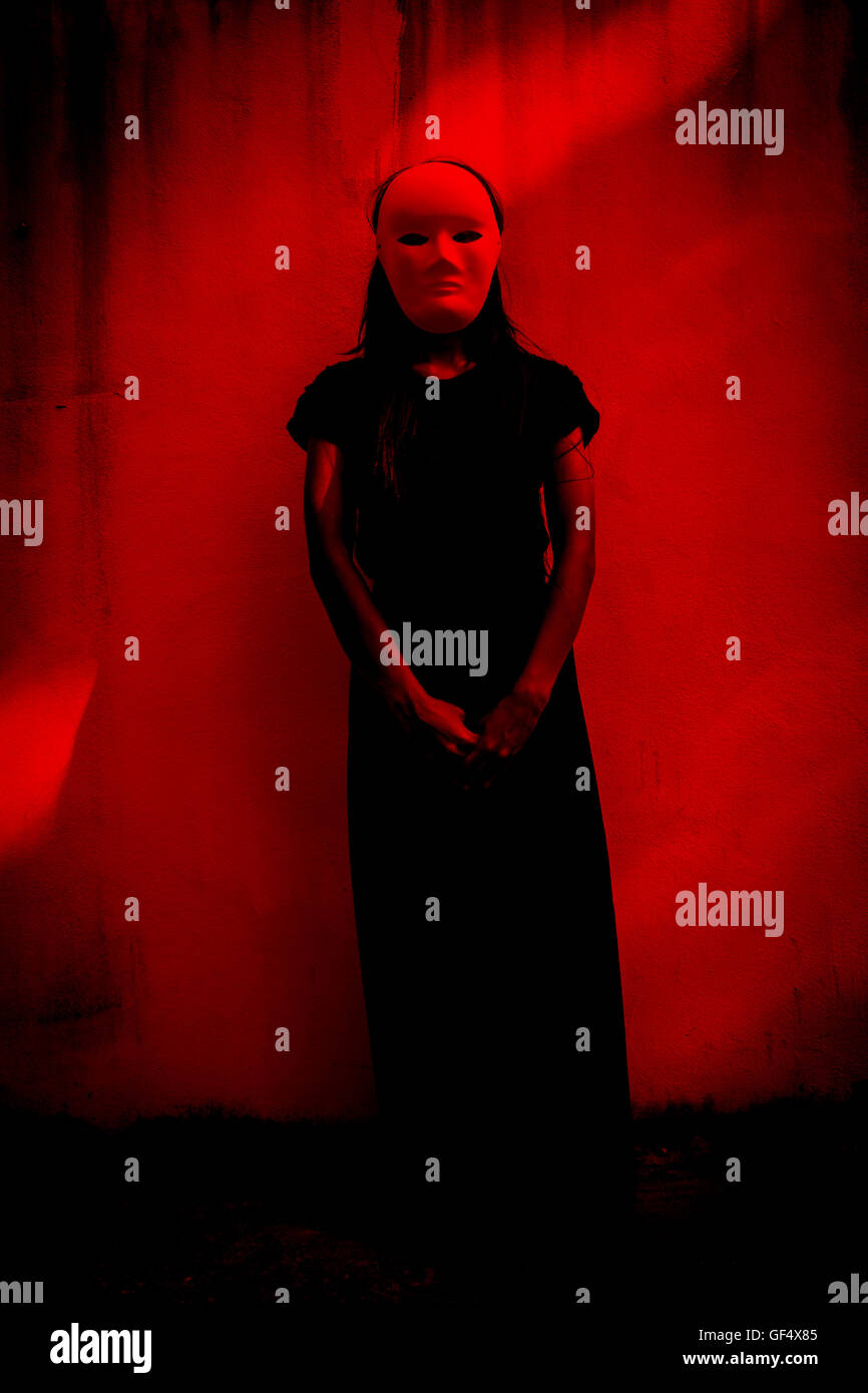 Mysterious woman in black dress wearing white mask,Scary background for