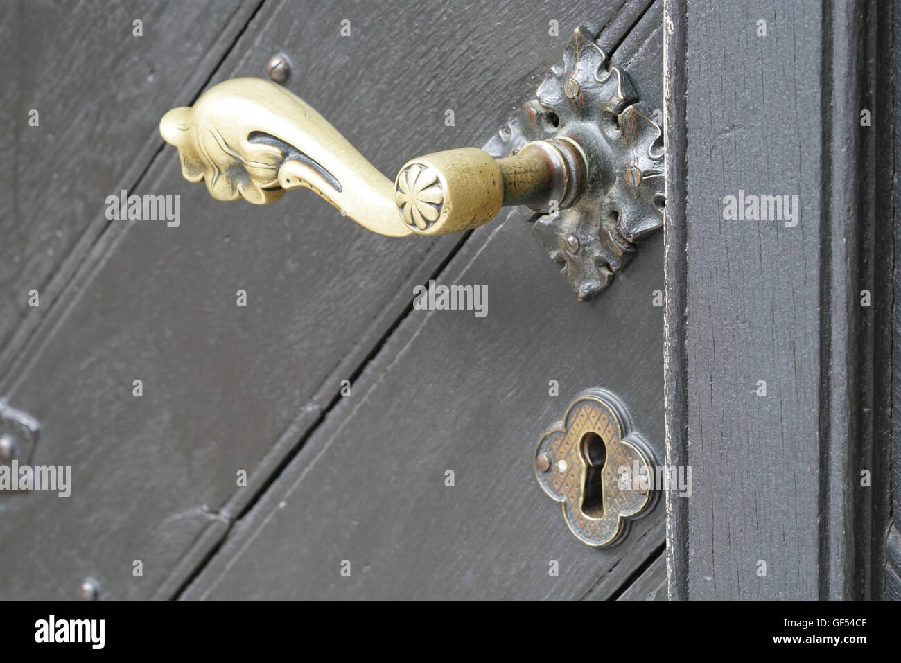 closeup of a grey door with a brass door knob Stock Photo
