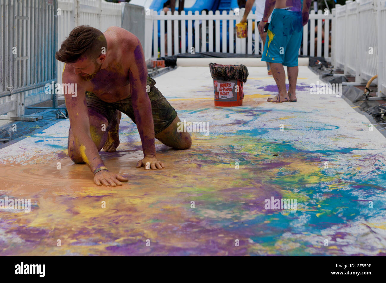 Men playing with paint at an outdoor festival - USA Stock Photo