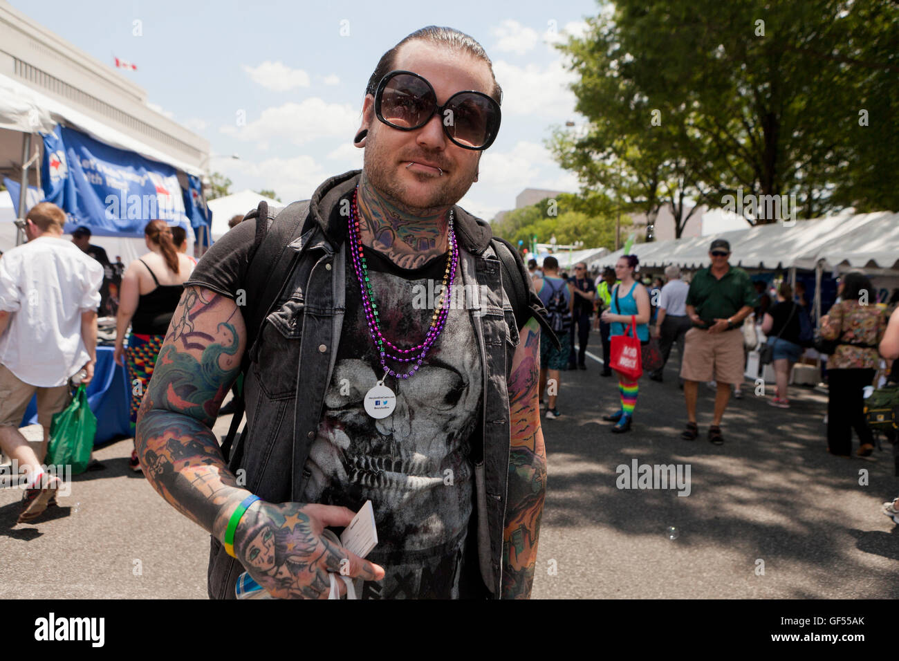 Man with many tattoos at an outdoor event - USA Stock Photo