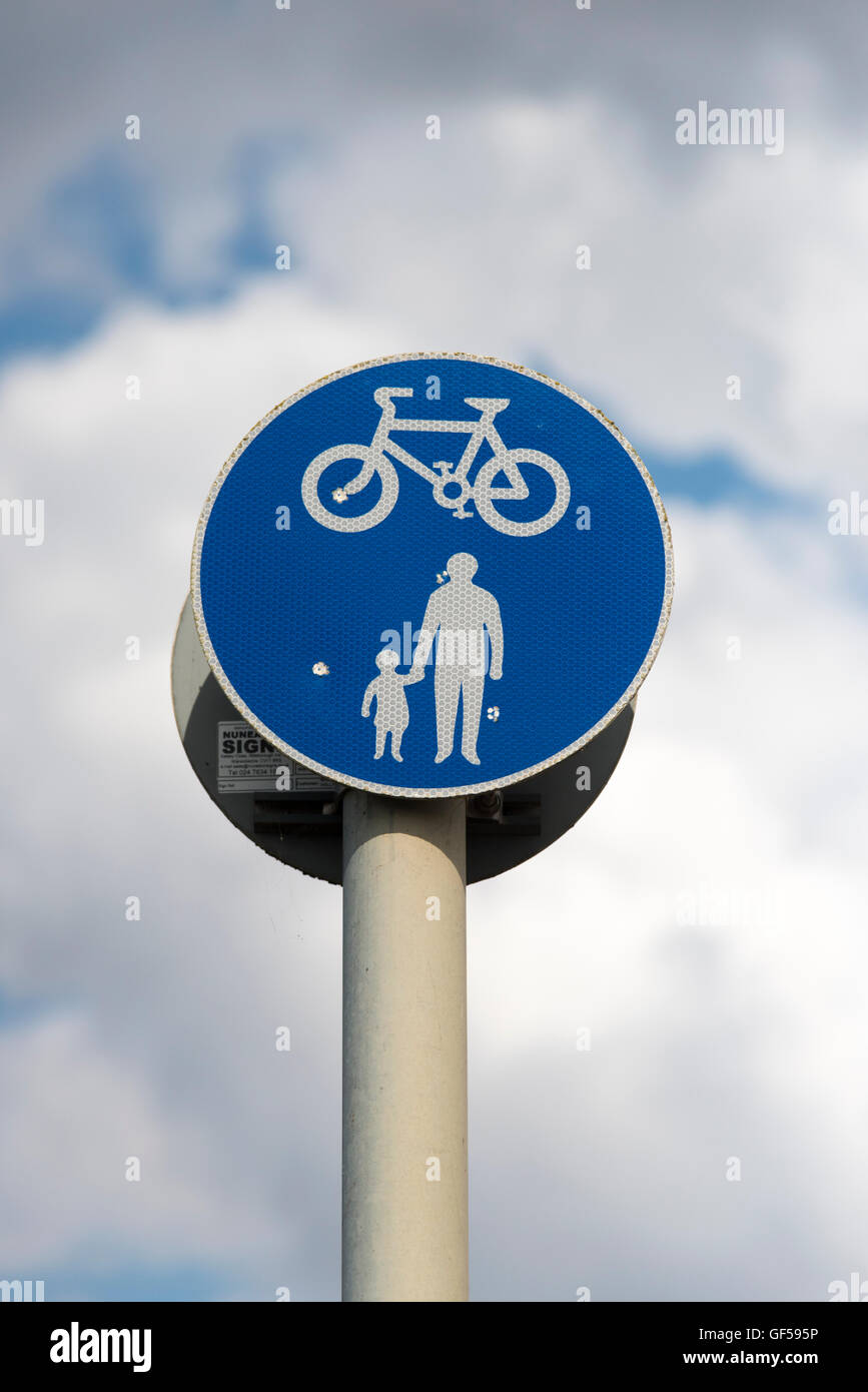 A blue circular road sign showing a shared footpath with cyclists and