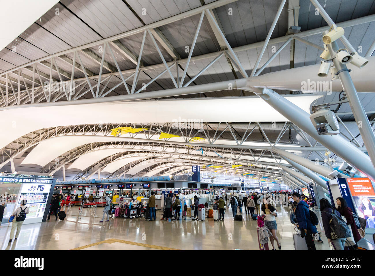 Japan, Kansai airport, KIX. Interior of terminal one building. International check-in. General view of hall with rows of check in desks and people. Stock Photo