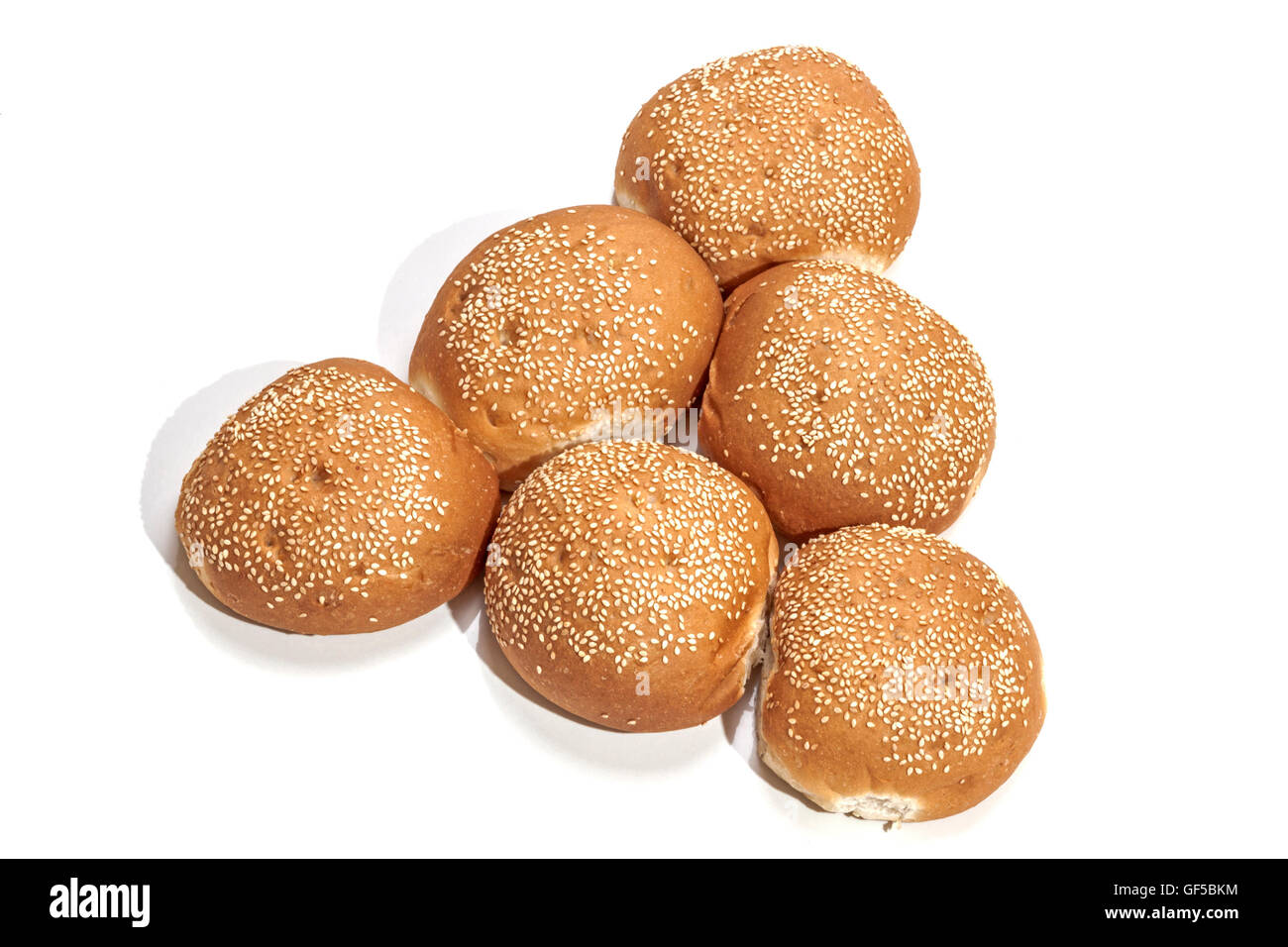 Freshly baked crisp golden hamburger buns assembled in triangular shape ...