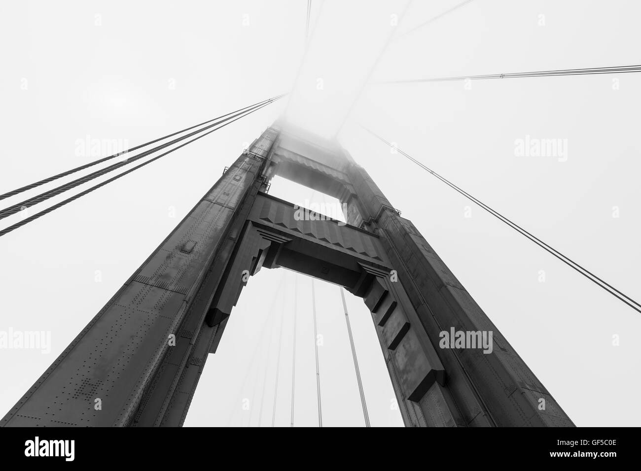 Golden Gate bridge tower emerging from iconic San Francisco bay fog bank in black and white. Stock Photo