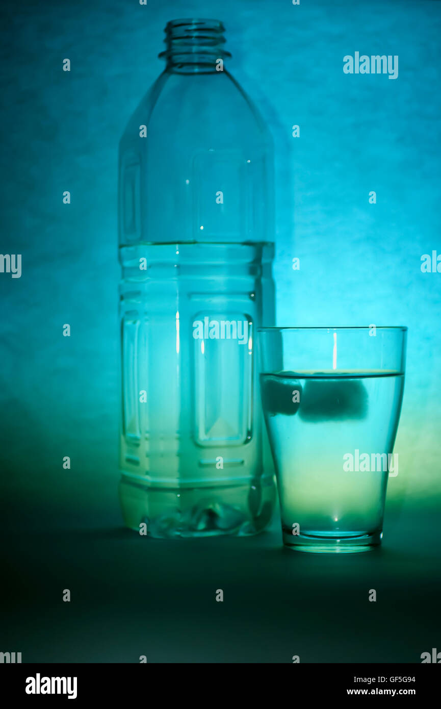a glass and bottle of refreshing mineral water with ice cubes Stock ...