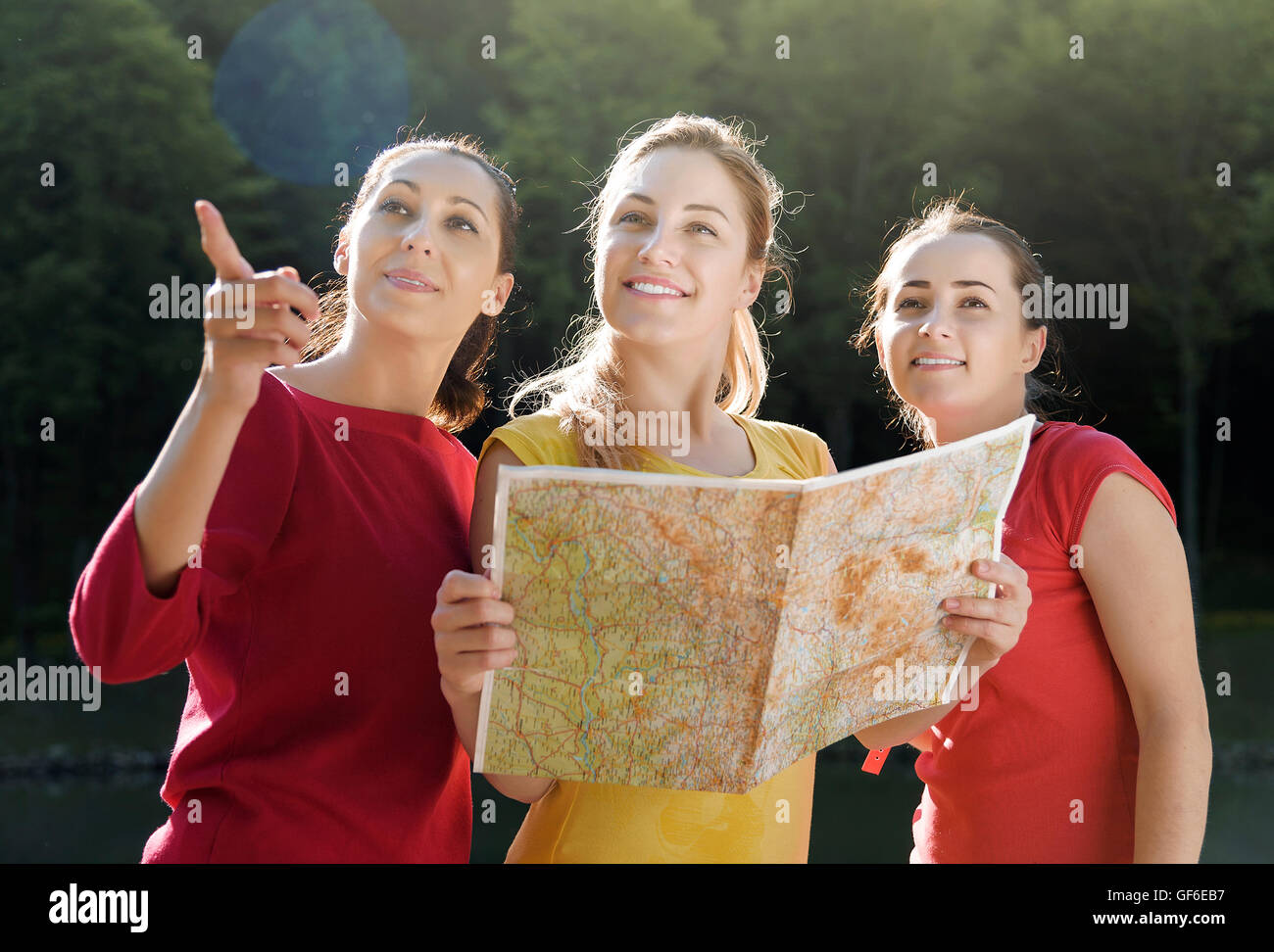 Holidays and tourism concept - beautiful girls with map in the rural Stock Photo