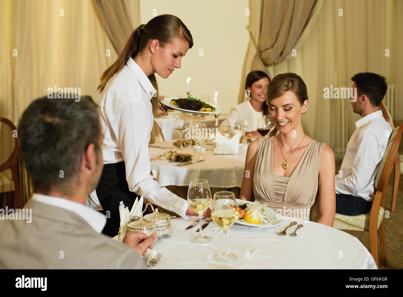 Waitress Serving Food To Man And Woman In Restaurant Stock Photo Alamy