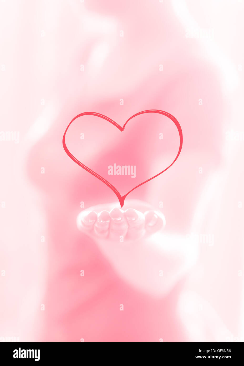 Female hand giving a heart on a pink background Stock Photo