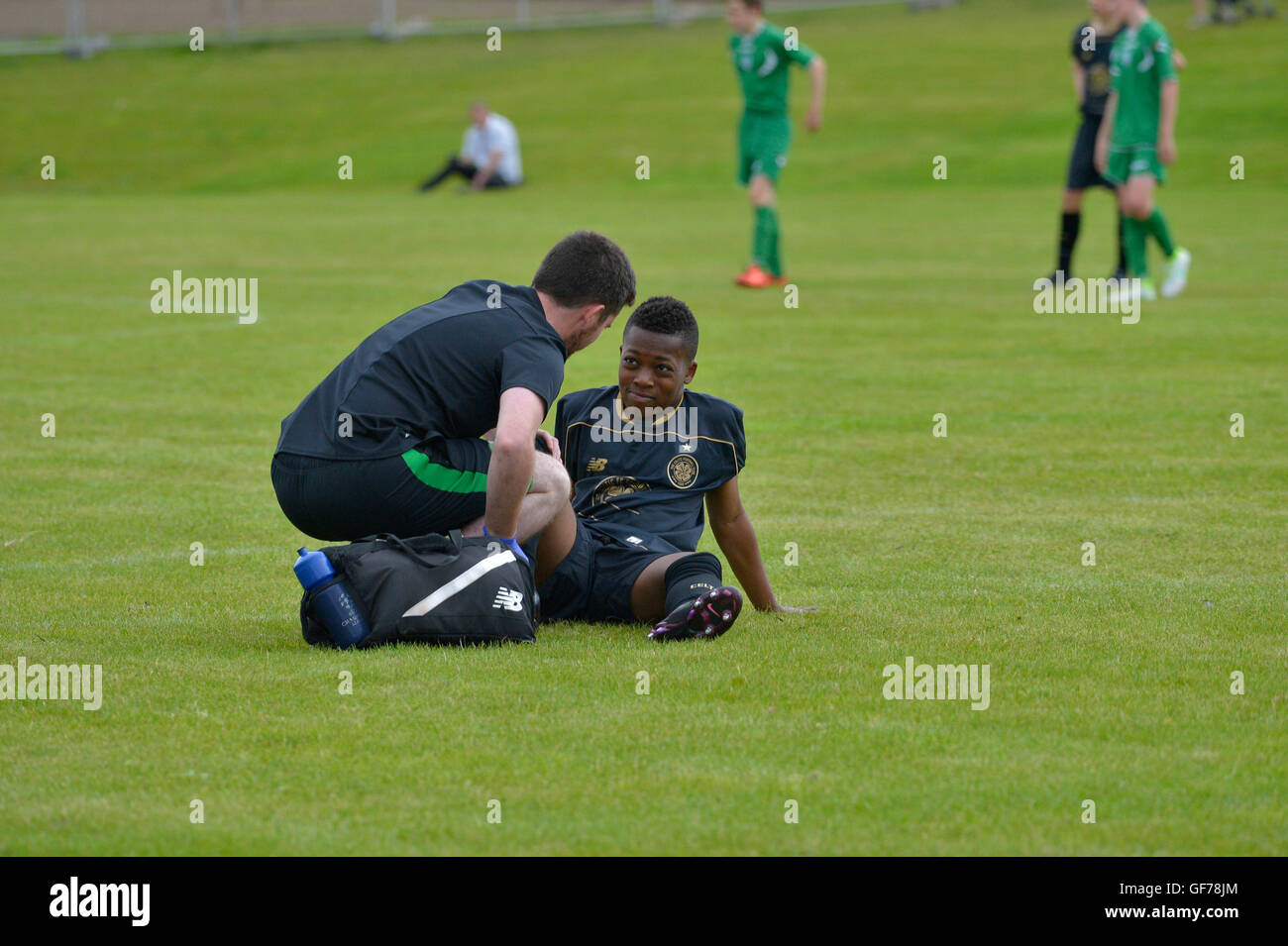 Glasgow Celtic Under 14 player receiving treatment for an injury in Foyle Cup game, Derry, Northern Ireland. Stock Photo