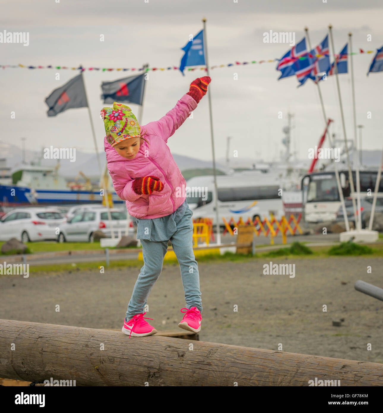 Young girl balancing on a log at The Annual Seaman's Festival, Hafnarfjordur, Iceland Stock Photo