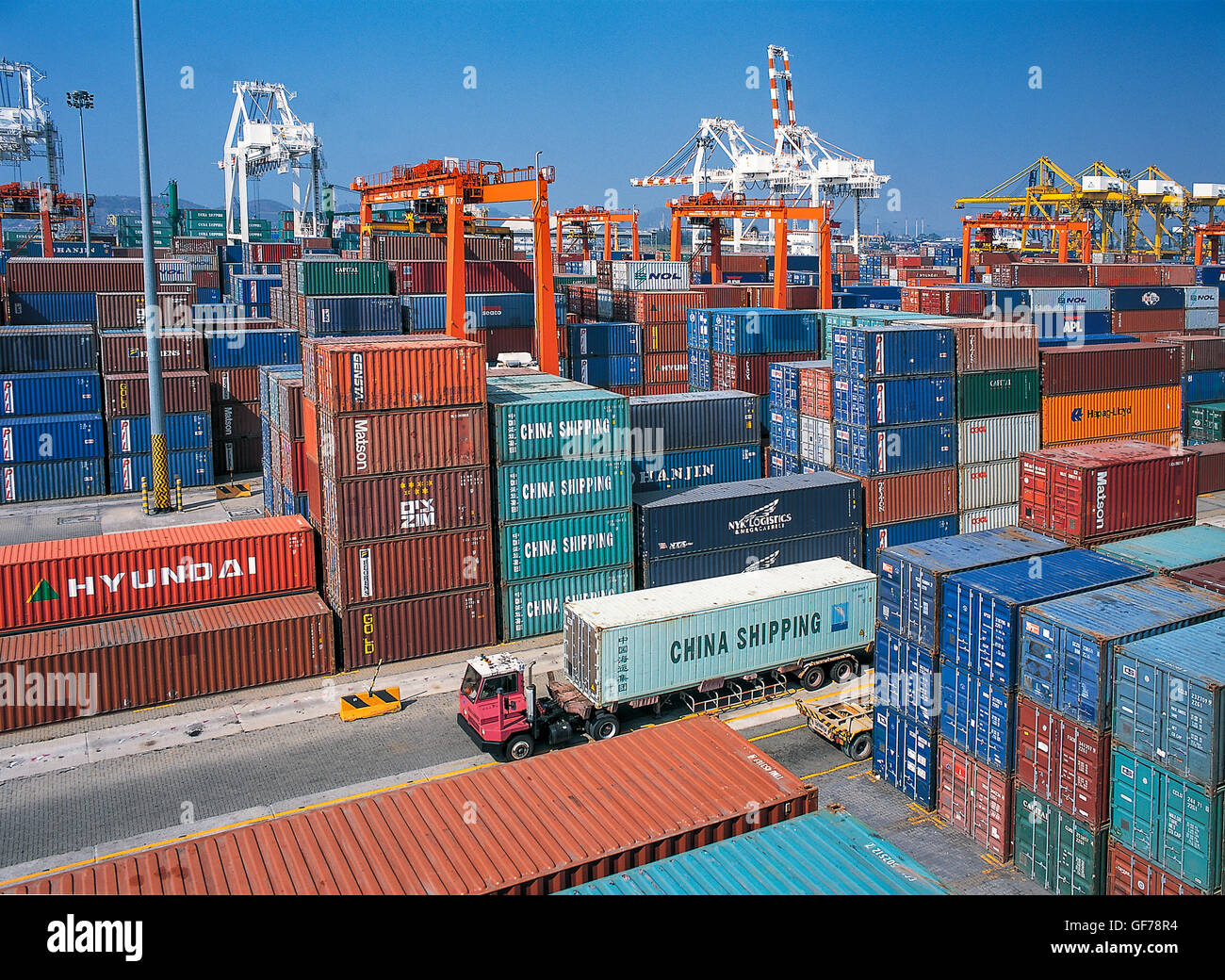 Moving containers from the truck by crane in port shipyard Stock Photo