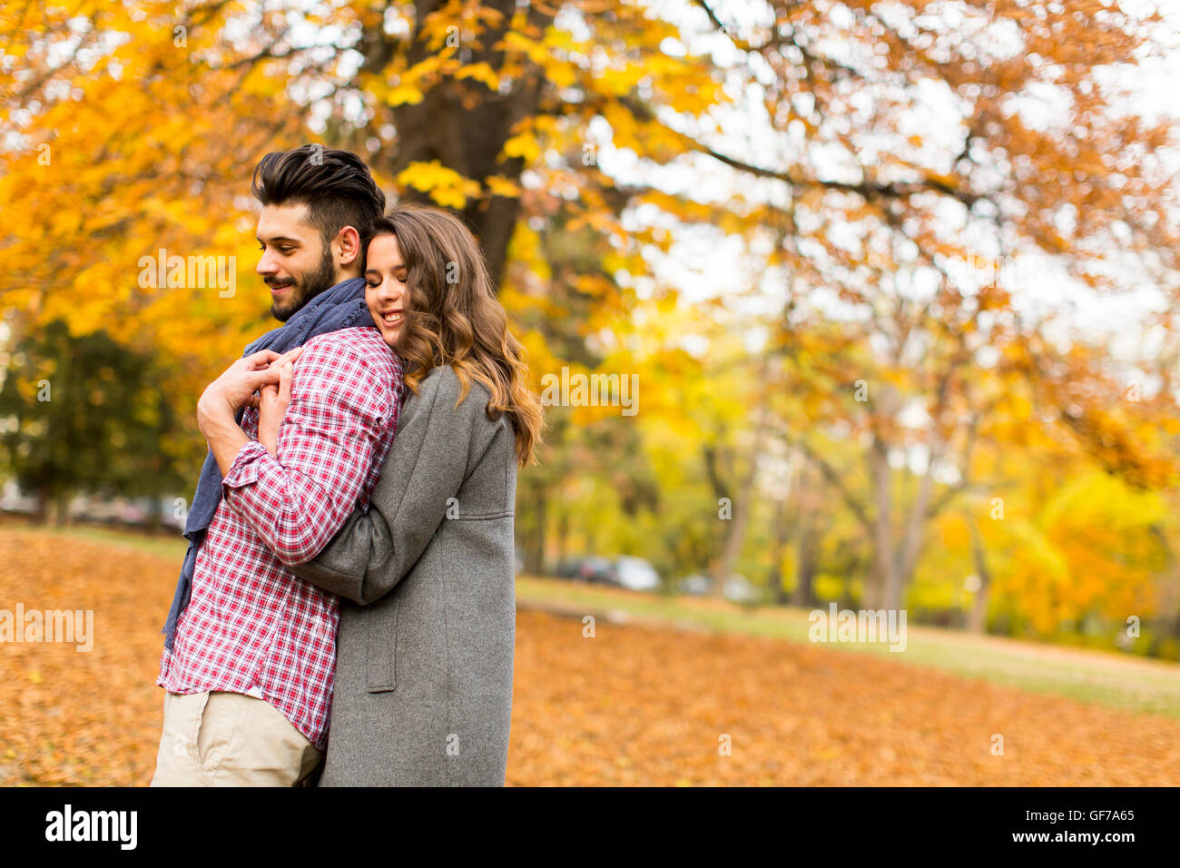 Young couple posing in the autumn park Stock Photo - Alamy