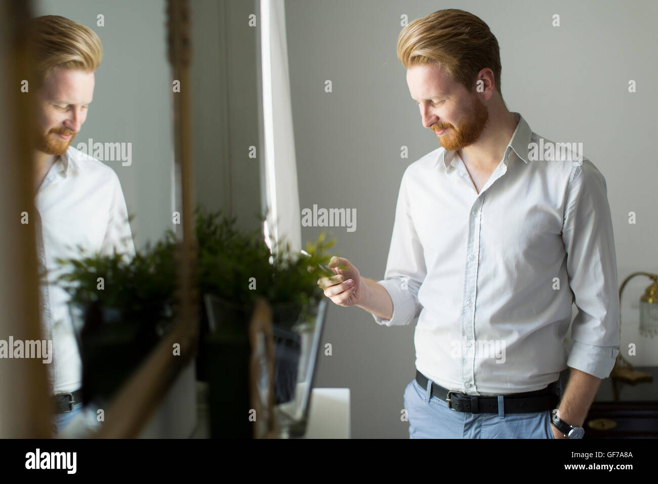 Handsome redhair man writes a message on the phone Stock Photo