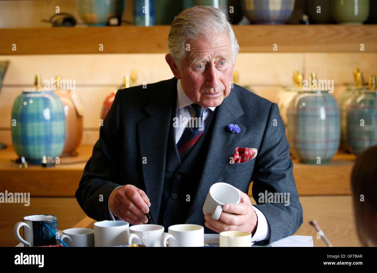 The Prince of Wales, also known as the Duke of Rothesay, paints a mug during a visit to Anta home furnishings in Fearn, Scotland, to see how the business supports traditional craft skills. Stock Photo