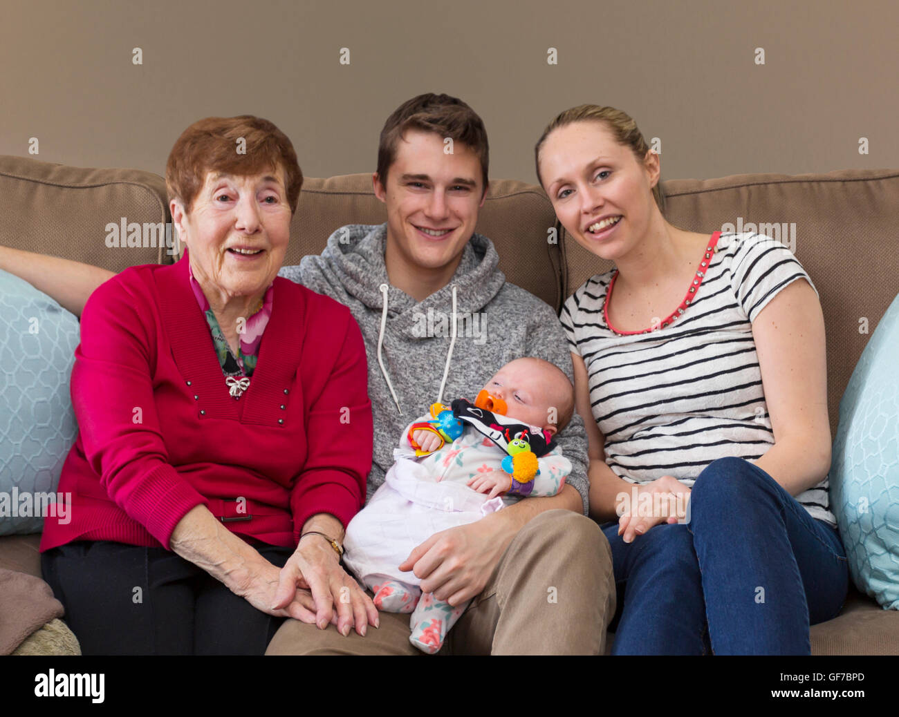 3 generations of people, multi generations of people sitting on sofa with baby Stock Photo
