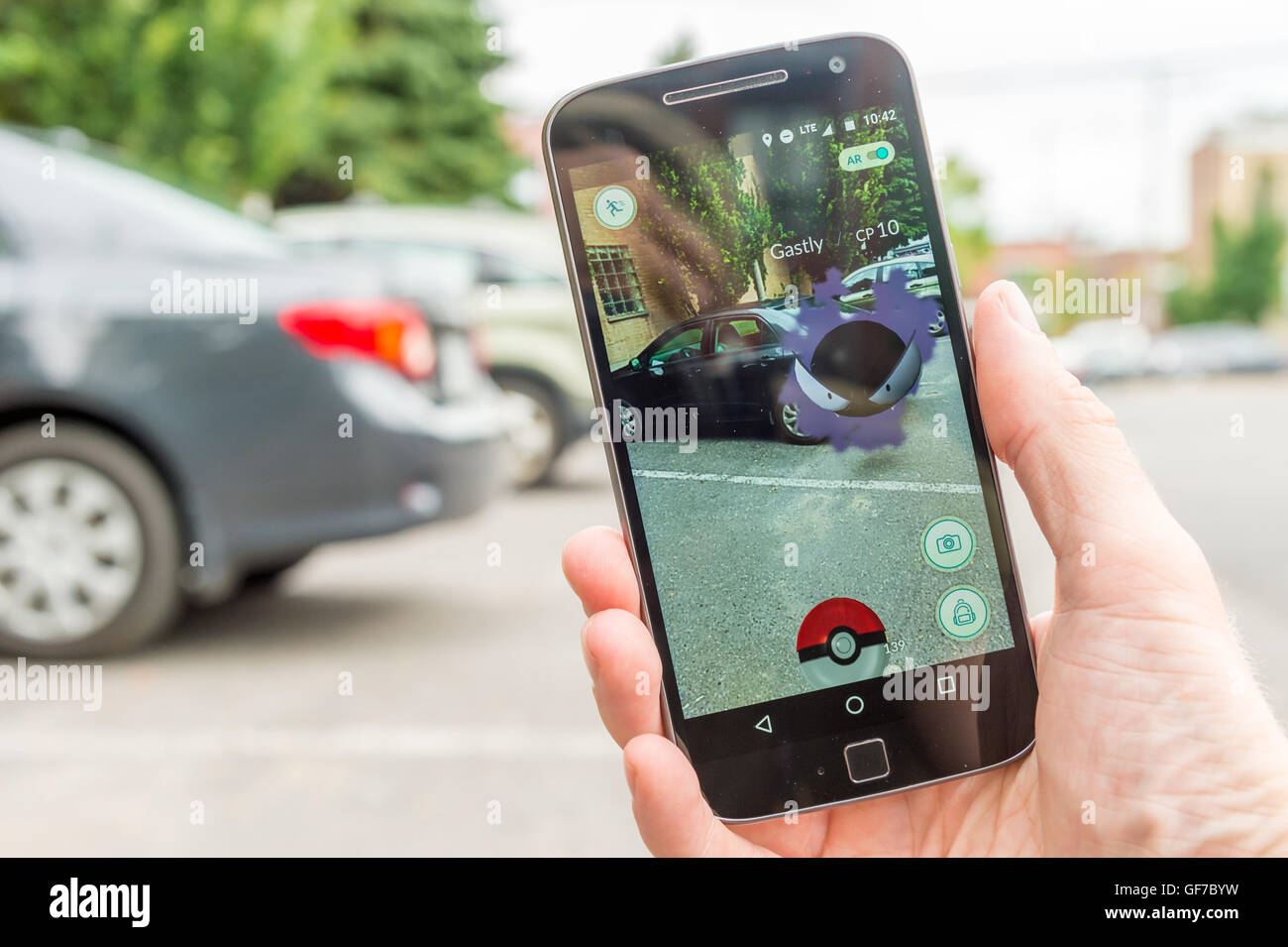 Montreal, CA - July 28, 2016: Closeup of a man playing Pokemon Go on a smart phone. Pokemon Go is a virtual reality game release Stock Photo