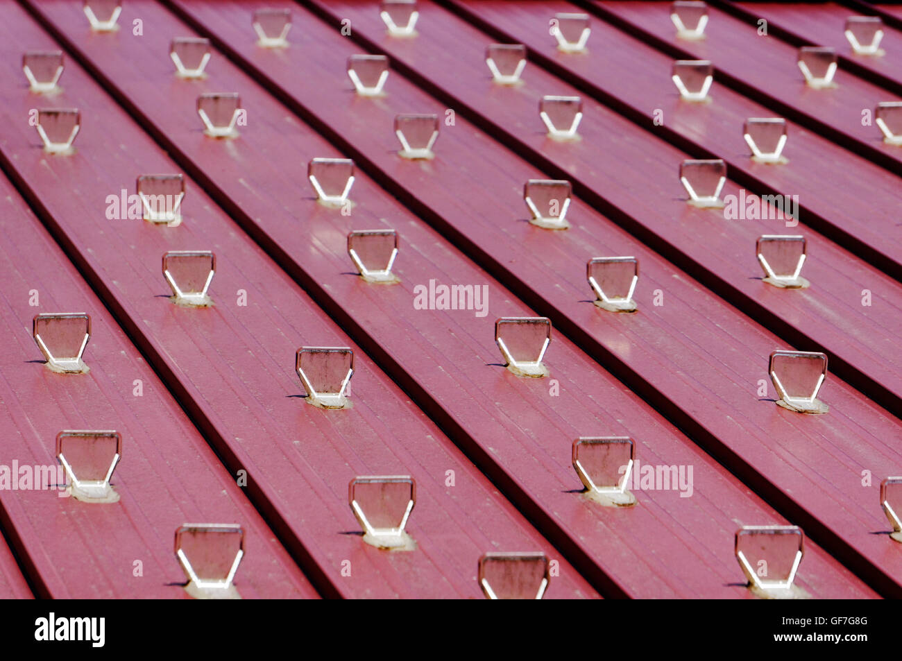 Clear plastic snow guards or snow stops attached to a sloping wooden roof Stock Photo
