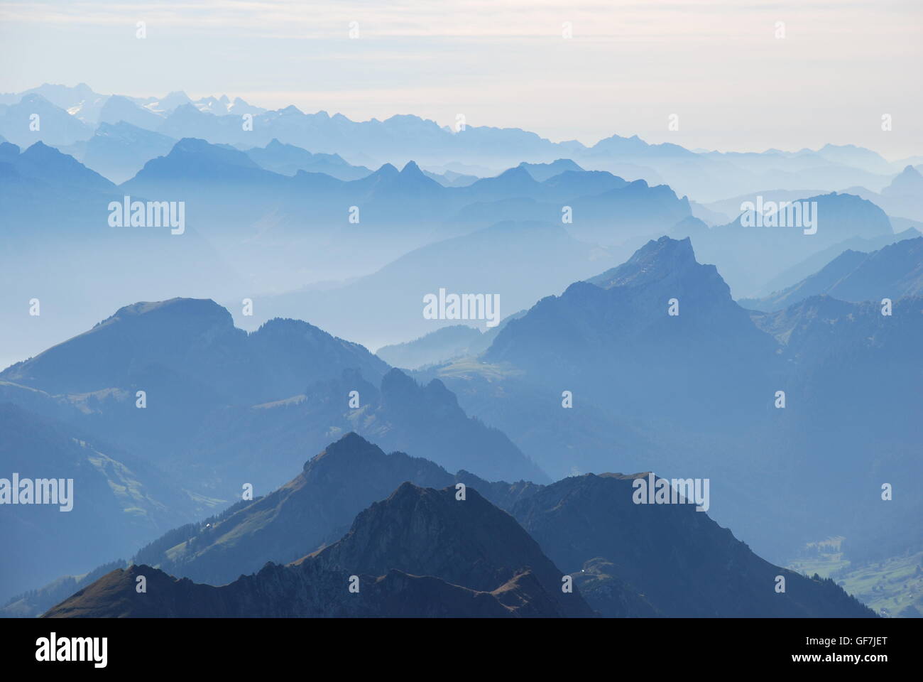 Blue mountain range in mist Swiss alps Stock Photo