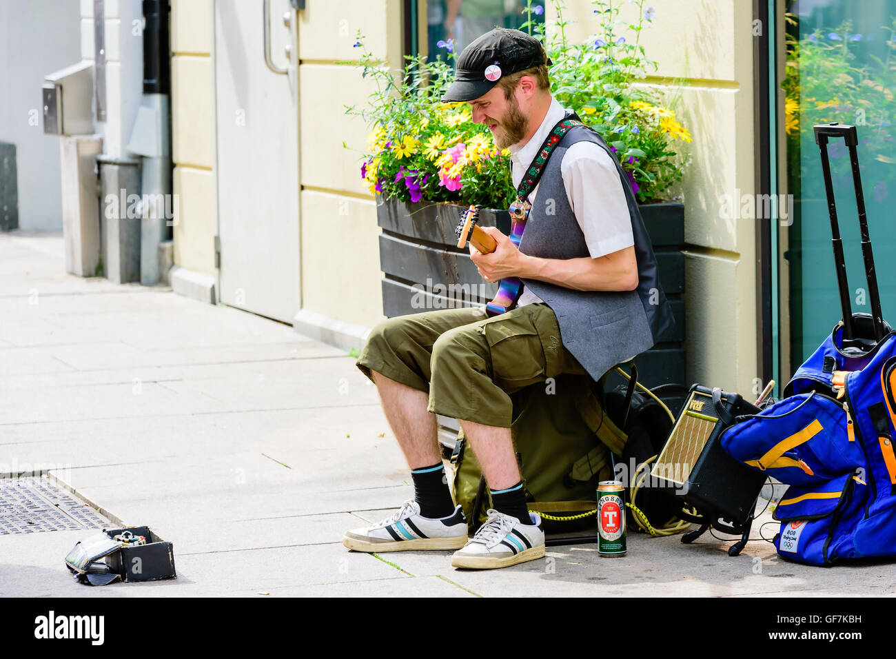 Goteborg, Sweden - July 25, 2016: Unknown street musician performing with his guitar. A can of beer beside him and an open case Stock Photo