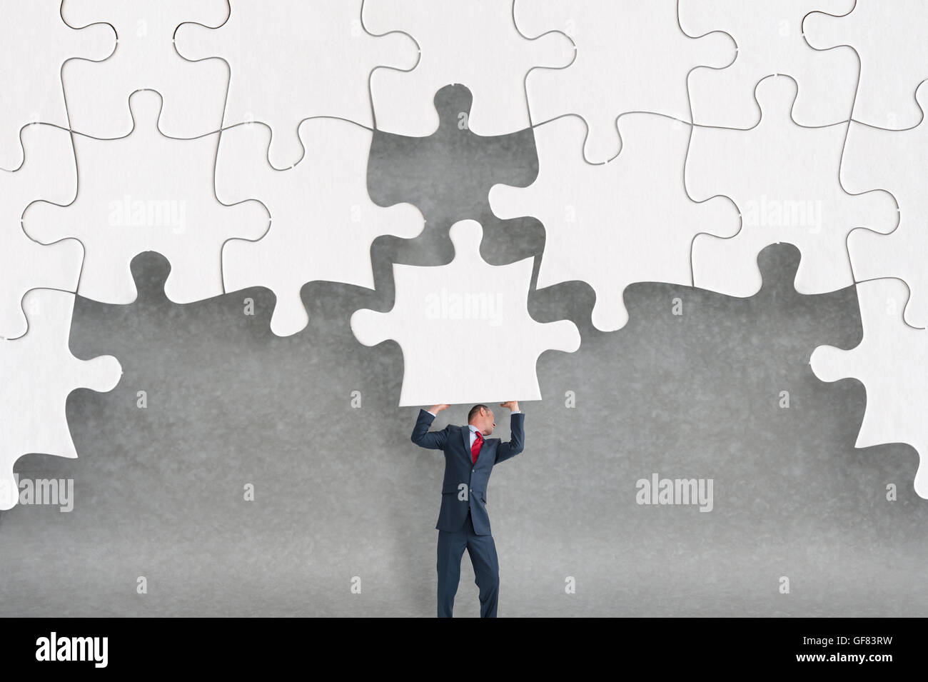 business challenge concept businessman completing a jigsaw puzzle Stock Photo