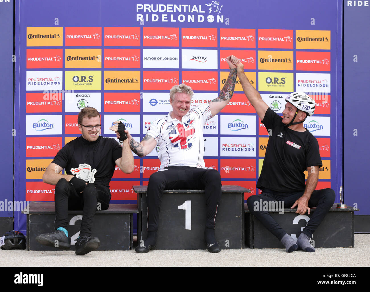 Winner of the handcycle race Jonathan Waters (centre) is congratulated by second-placed James Pierce (left) and third-placed Gary Donald on the podium, during the Prudential RideLondon Grand Prix at the Lee Valley VeloPark, Queen Elizabeth Olympic Park, in London. Stock Photo