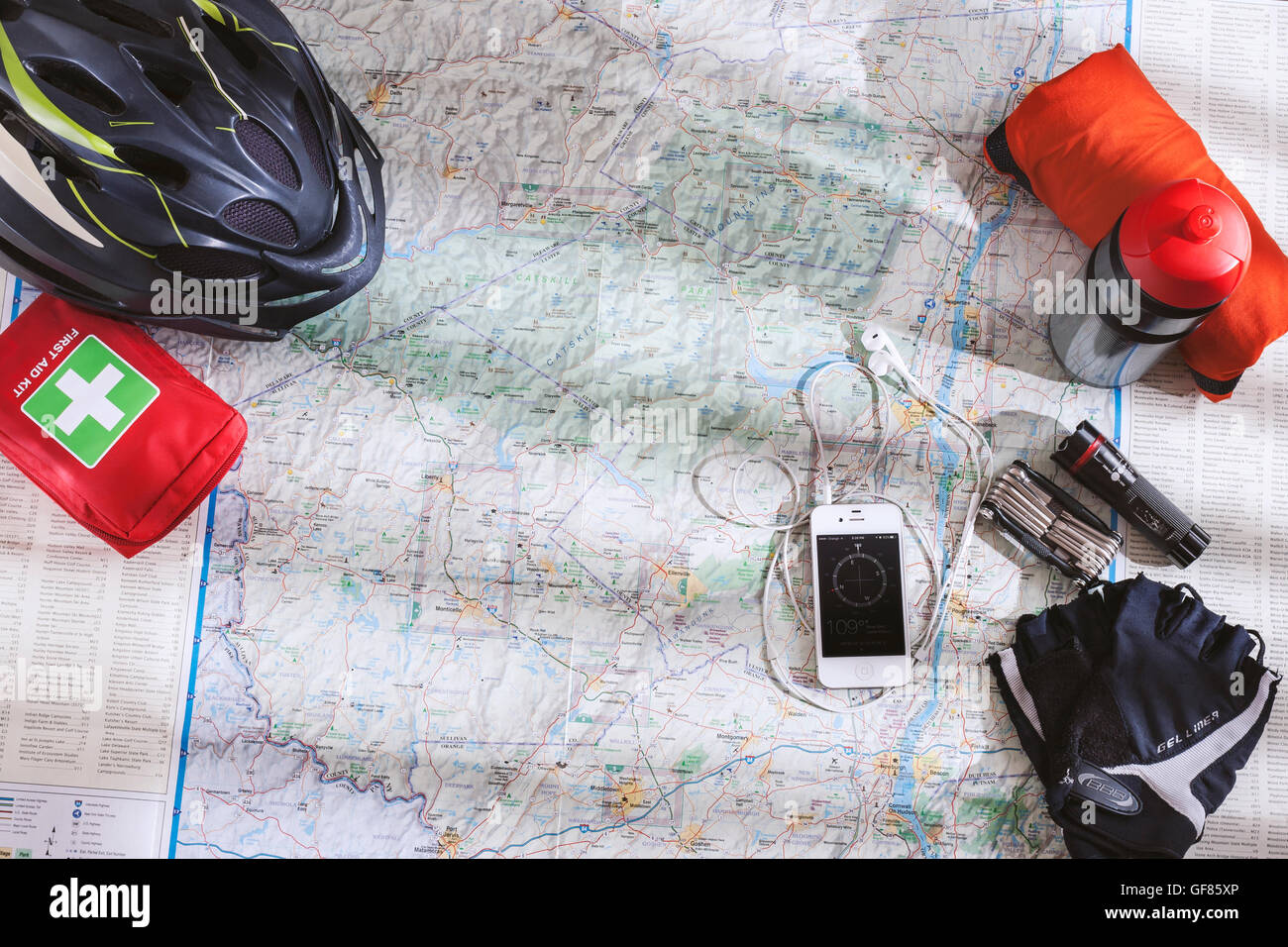 Bicycle accessories spread out on the map when planning a bike trip in the Catskill mountains with compass app on smartphone Stock Photo