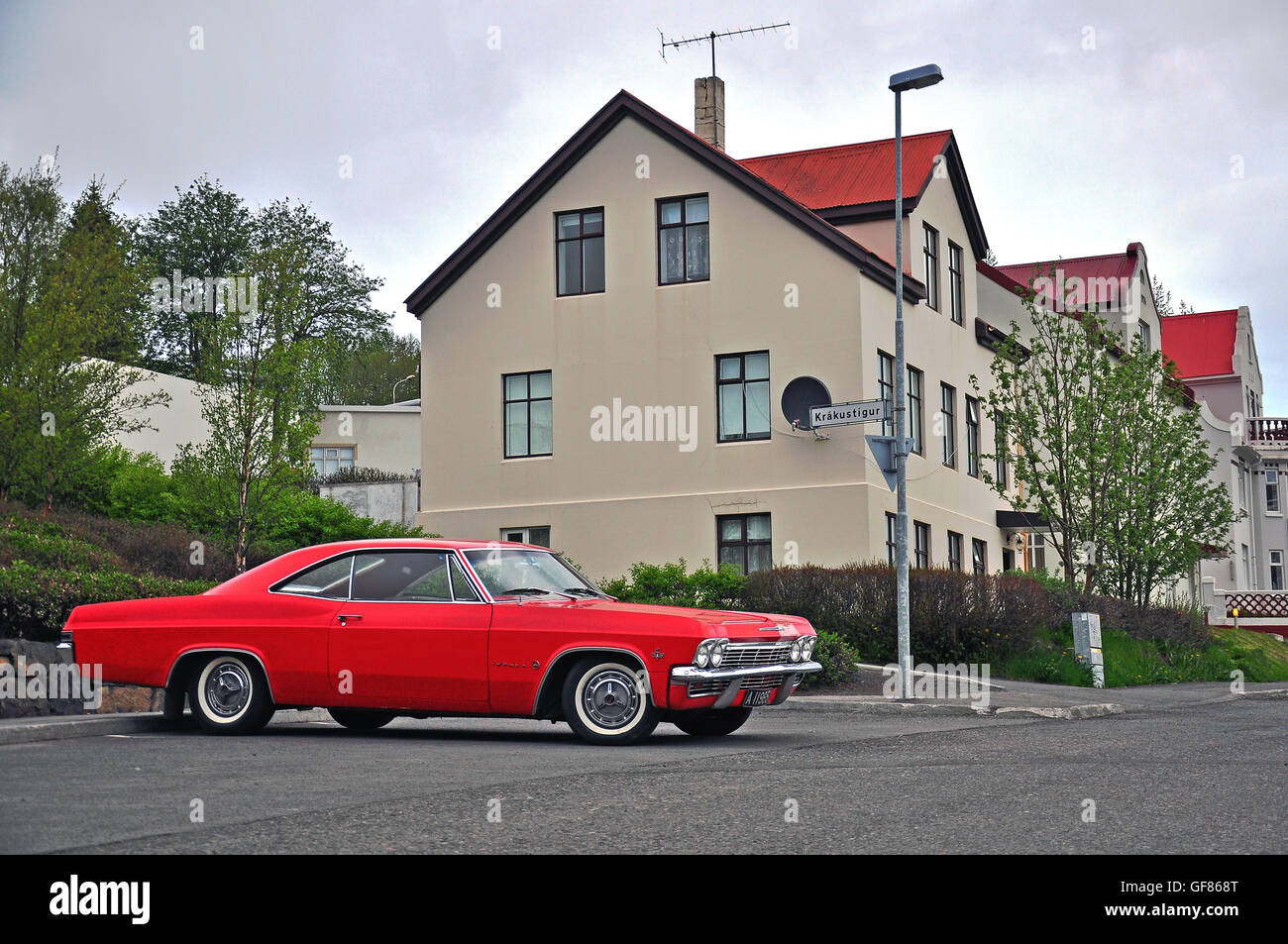 AKUREYRI, ICELAND - JUNE 4: The red old fashioned car parked in the street of Akureyri on June 4, 2013. Akureyri is the second l Stock Photo