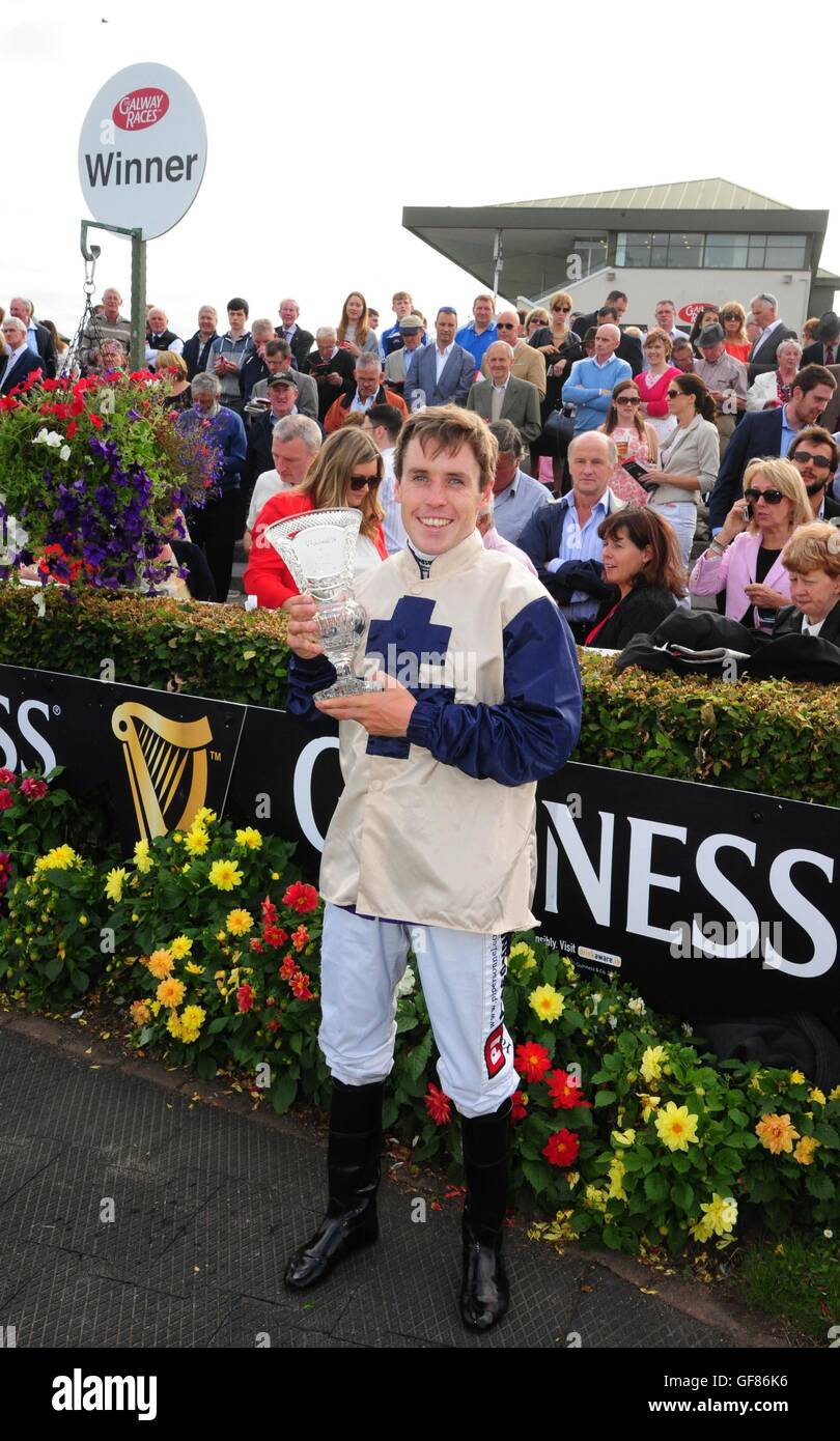 Jockey Leigh Roche with the trophy after winning the Featured Guinness Handicap onboard Golden Spear during day five of the Galway Festival in Ballybrit, Ireland. Stock Photo