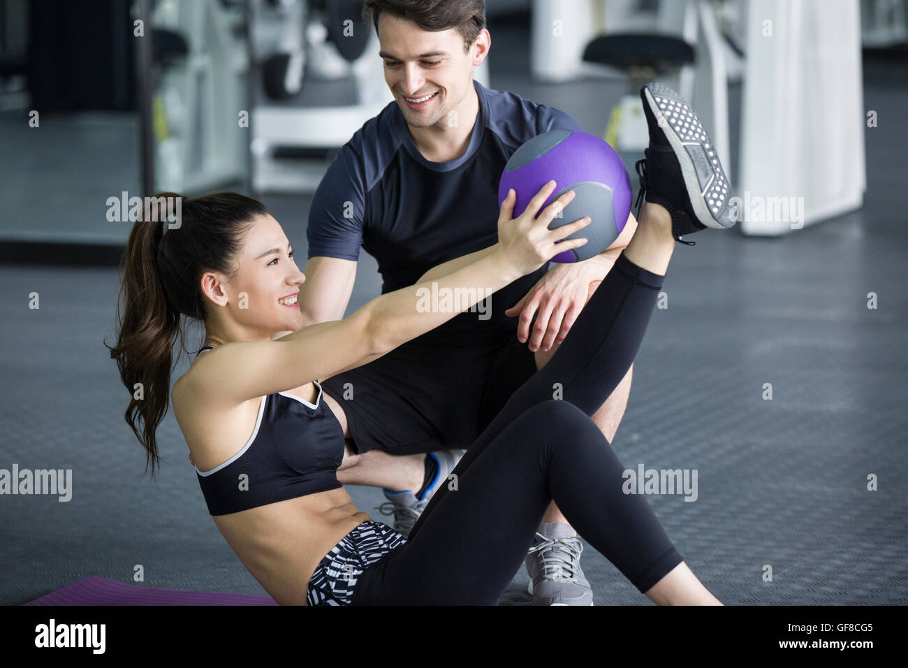 Young Chinese woman working with trainer at gym Stock Photo - Alamy