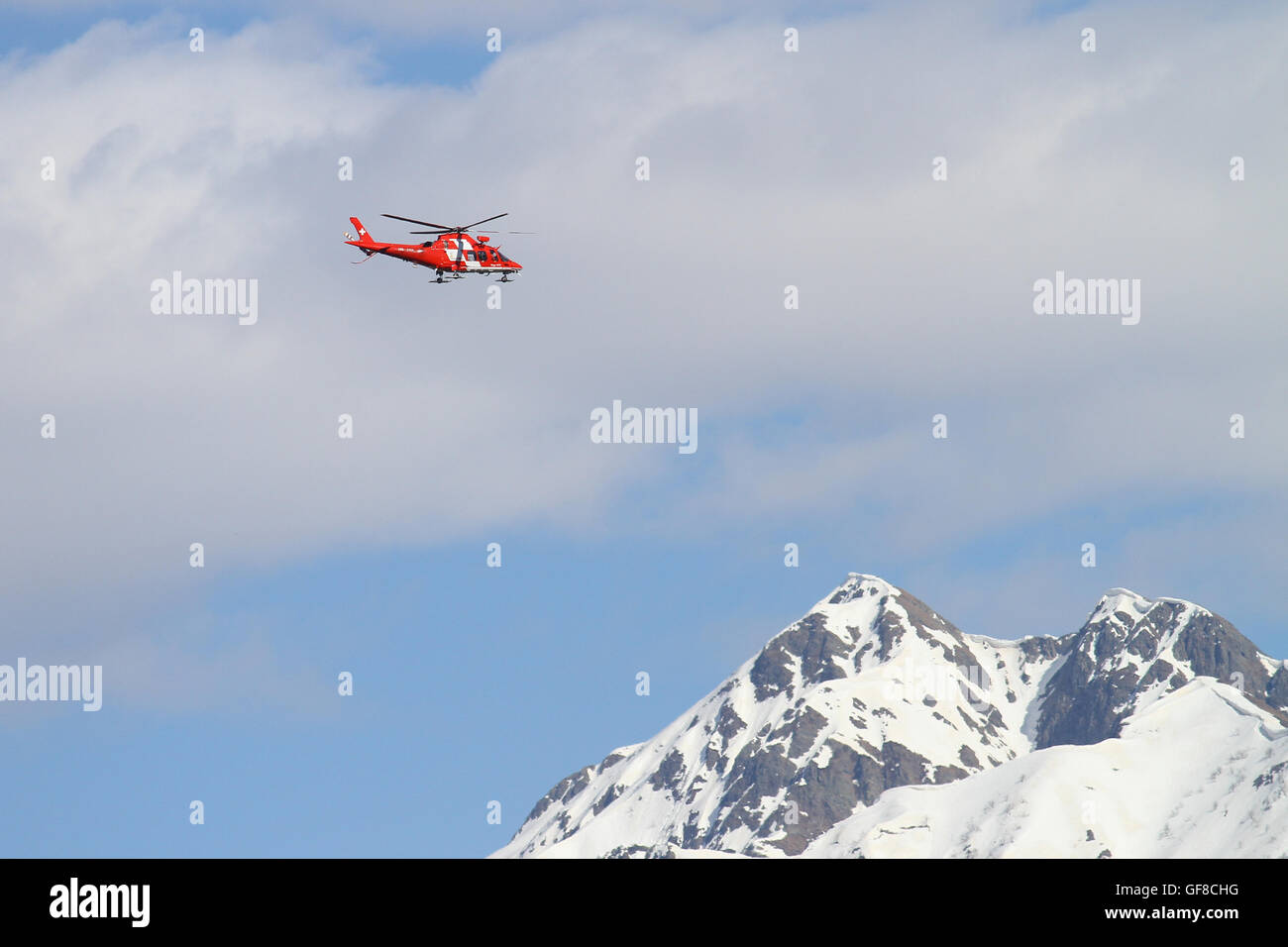 Rega Agusta 109  helicopter during a high altitude mountain rescue operation in the Alps in May 2016 Stock Photo