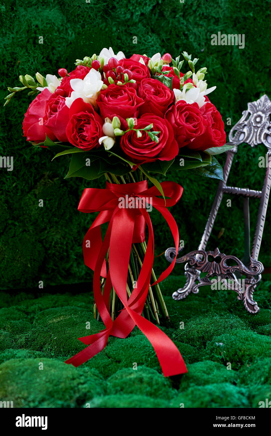 dense red bouquet of roses, tied with a red ribbon. Close Stock Photo