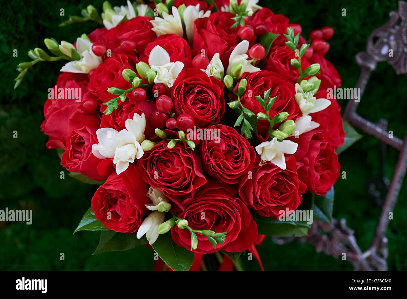 dense red bouquet of roses, with red berries and decor. Close Stock Photo