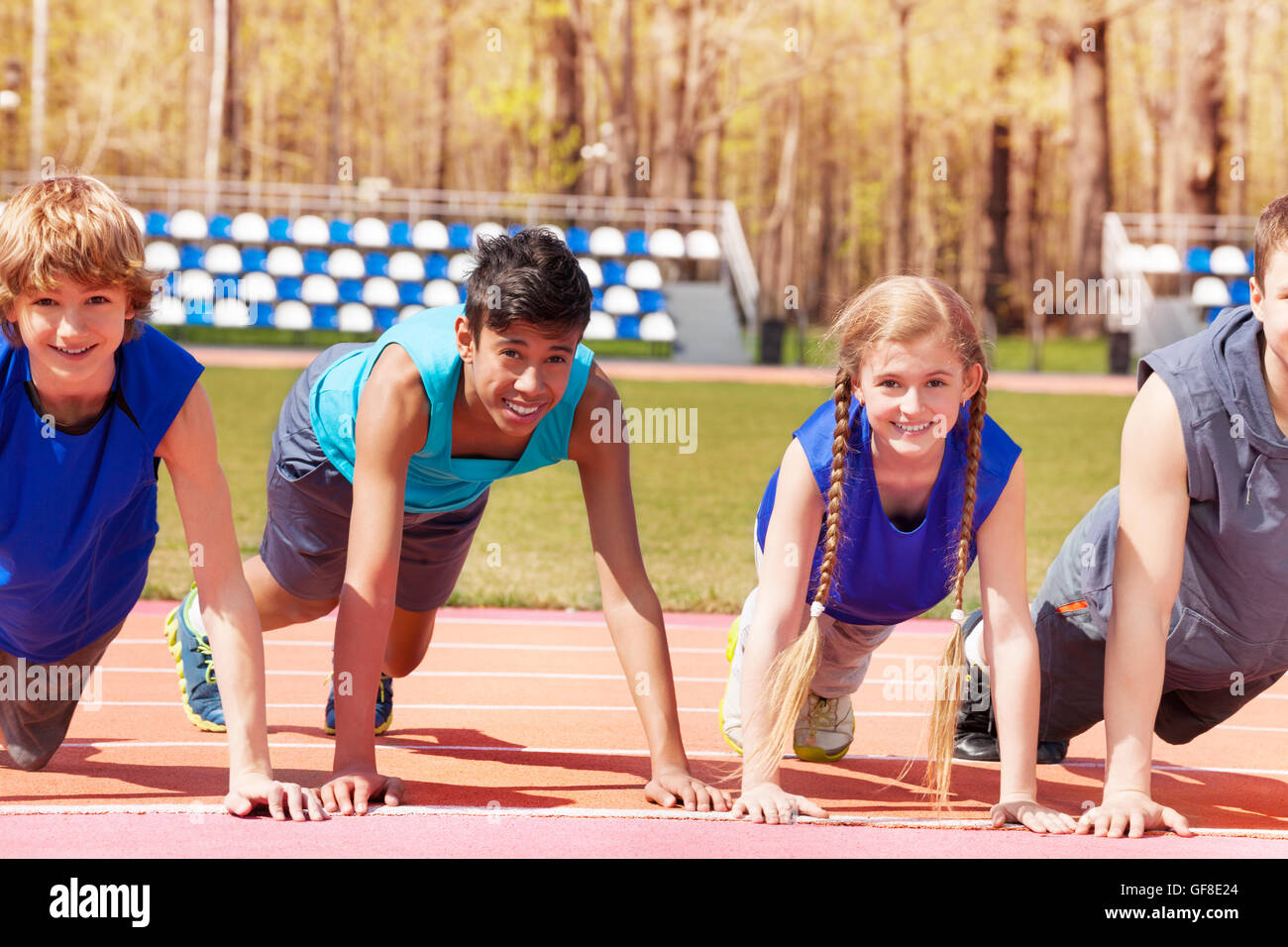 Happy teens doing push-up exercises on the track Stock Photo