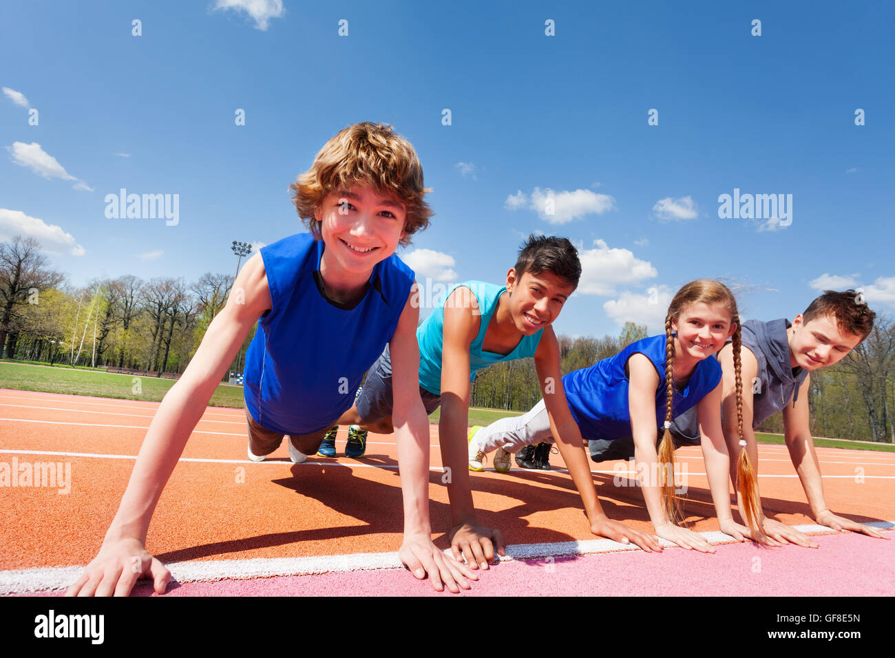 Happy teenagers holding plank outdoor on the track Stock Photo