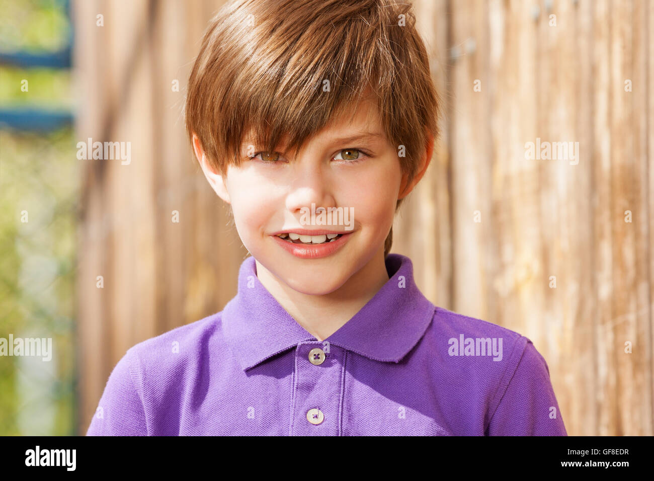 Portrait of ten years old boy in purple polo shirt Stock Photo