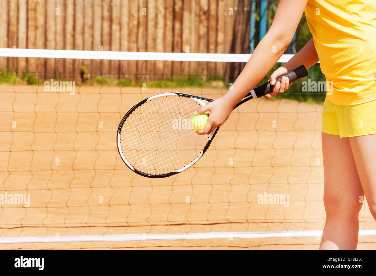 Tennis player with ball and racket on a clay court Stock Photo