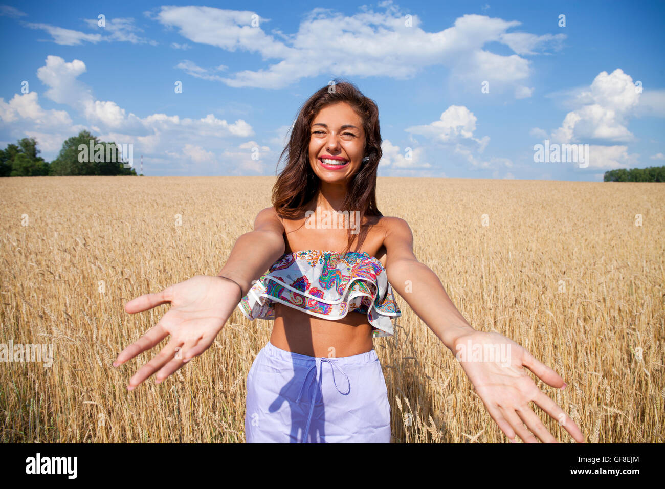 Beautiful young woman in a wheat golden field Stock Photo - Alamy