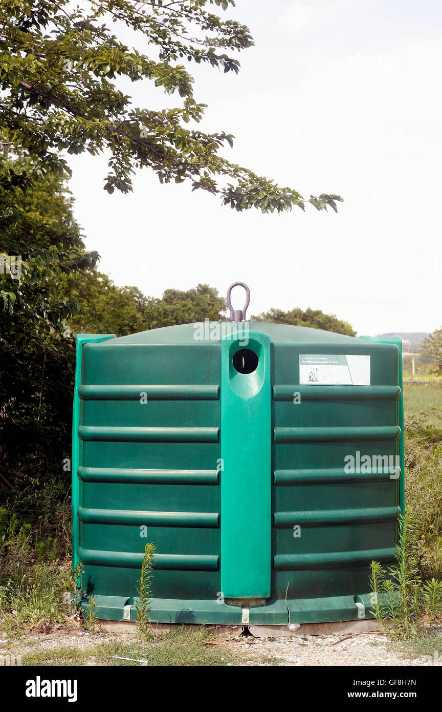 Recycling bin for bottles and glass jars on the side of the road in the