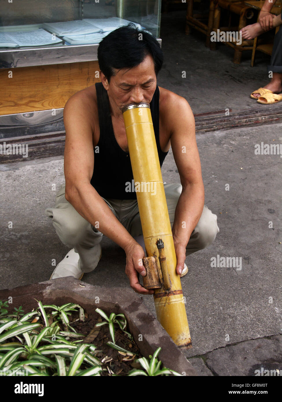 Man smoking a bamboo pipe in Ciqikou Ancient Town, a part of old Chongqing, China. Stock Photo