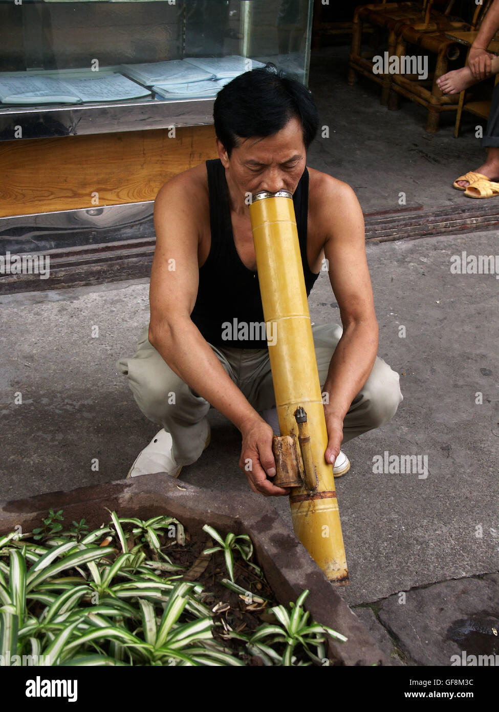 Man smoking a bamboo pipe in Ciqikou Ancient Town, a part of old Chongqing, China. Stock Photo