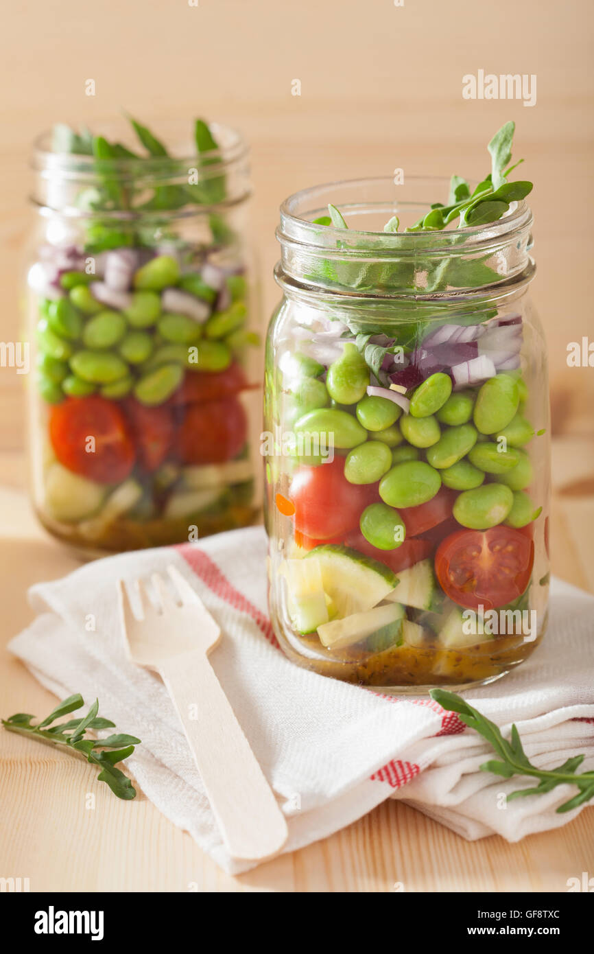 healthy vegetable salad in mason jar tomato, cucumber, soybean, onion