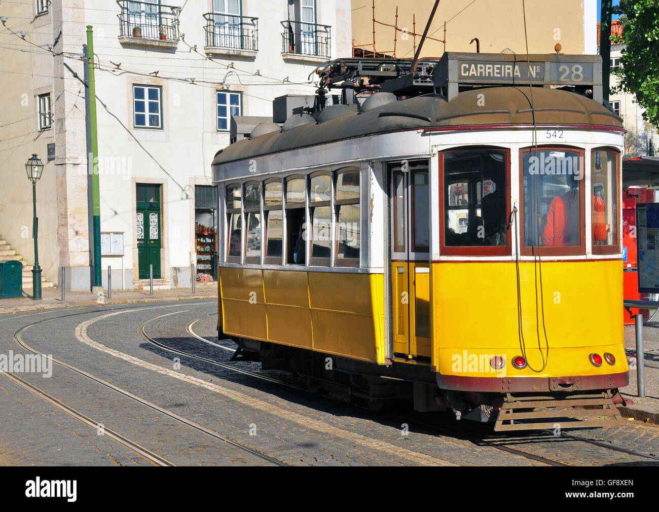 Lisbon yellow tram crosses Alfama streets Stock Photo