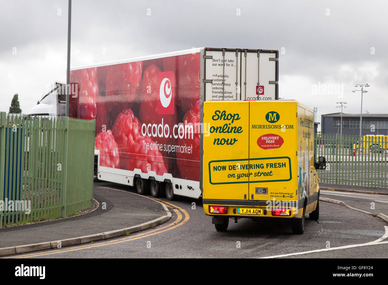 Ocado raspberry van livery & Morrisons supermarket grocery delivery service food store vehicles; online delivery fleet delivering, groceries & household essentials in Liverpool, Merseyside, UK Stock Photo