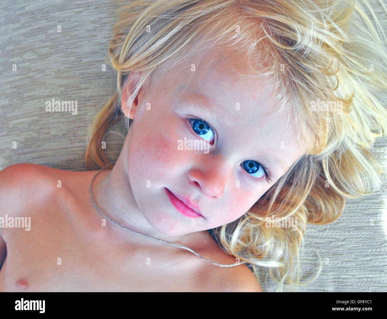 Cute baby with long blonde hair Stock Photo